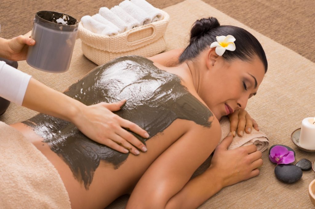 girl enjoying a mud body treatment and relaxing